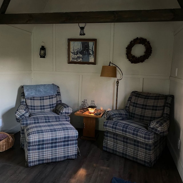 living area featuring beam ceiling and dark wood-type flooring