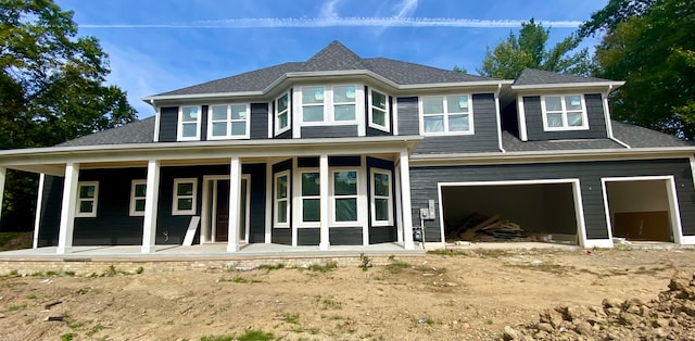 rear view of house featuring covered porch and a garage