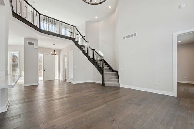 foyer featuring an inviting chandelier, dark hardwood / wood-style flooring, and a high ceiling