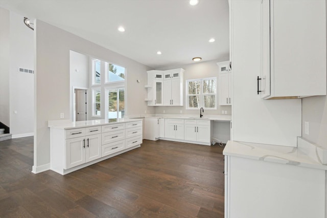 kitchen featuring light stone counters, sink, dark hardwood / wood-style flooring, and white cabinets