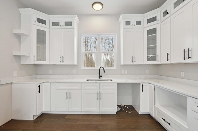 kitchen featuring light stone counters, sink, and white cabinets