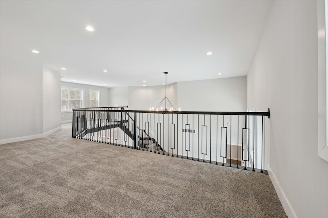 hall featuring a chandelier and carpet floors