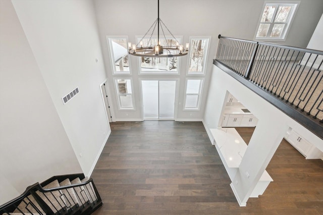 entrance foyer featuring dark hardwood / wood-style floors, a chandelier, and a high ceiling