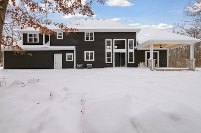 snow covered rear of property with ceiling fan