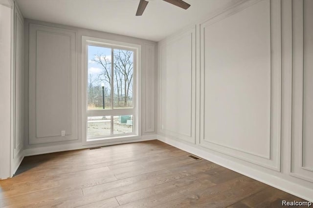 empty room with ceiling fan and light hardwood / wood-style floors