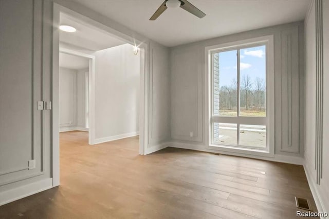 unfurnished room with hardwood / wood-style floors and ceiling fan