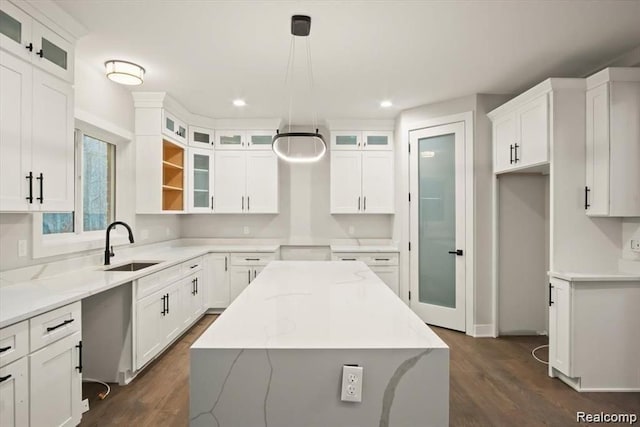 kitchen with white cabinetry, dark hardwood / wood-style flooring, a kitchen island, and hanging light fixtures