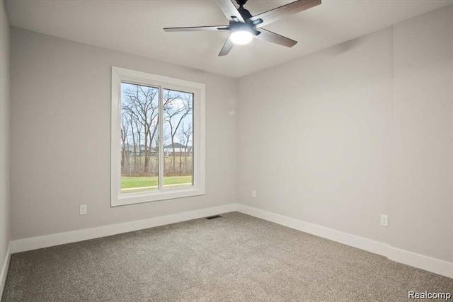 carpeted spare room featuring ceiling fan