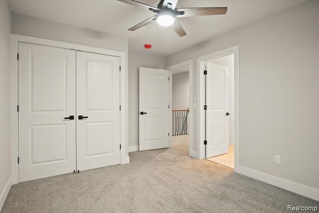 unfurnished bedroom featuring ceiling fan, light colored carpet, and a closet