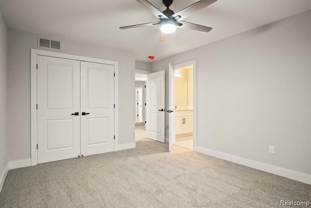 unfurnished bedroom featuring light colored carpet, a closet, and ceiling fan