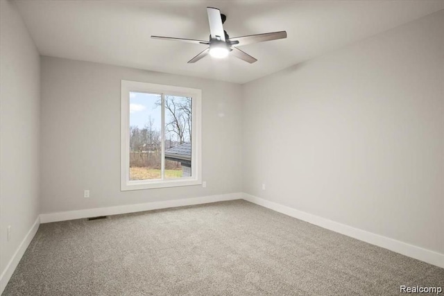 empty room featuring ceiling fan and carpet