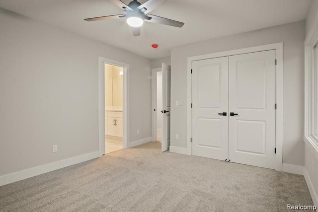 unfurnished bedroom with light carpet, a closet, ensuite bath, and ceiling fan