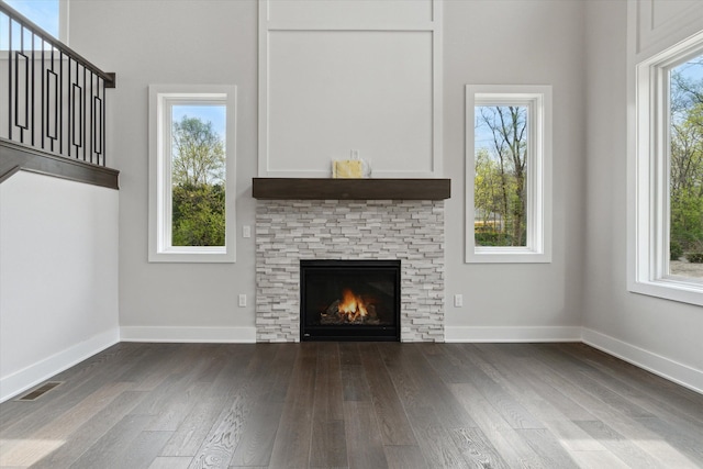 unfurnished living room with baseboards, a fireplace, wood finished floors, and visible vents