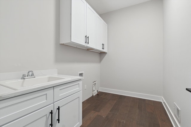 laundry area with visible vents, cabinet space, a sink, hookup for a washing machine, and dark wood-type flooring