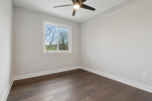 unfurnished room with dark wood-style flooring, a ceiling fan, baseboards, and visible vents