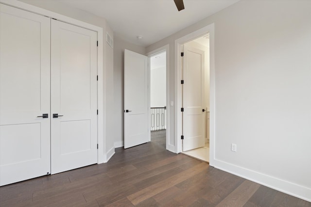 unfurnished bedroom with ceiling fan, dark wood-style flooring, visible vents, baseboards, and a closet