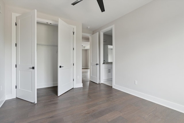 unfurnished bedroom featuring baseboards, wood finished floors, ensuite bathroom, and a closet
