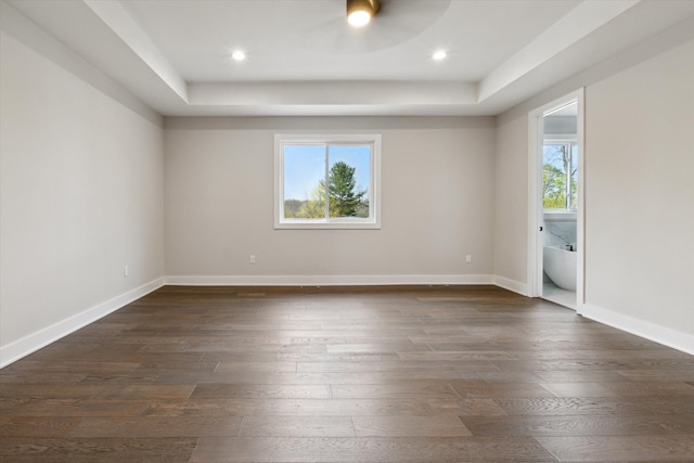 spare room with a healthy amount of sunlight, baseboards, recessed lighting, and dark wood-type flooring