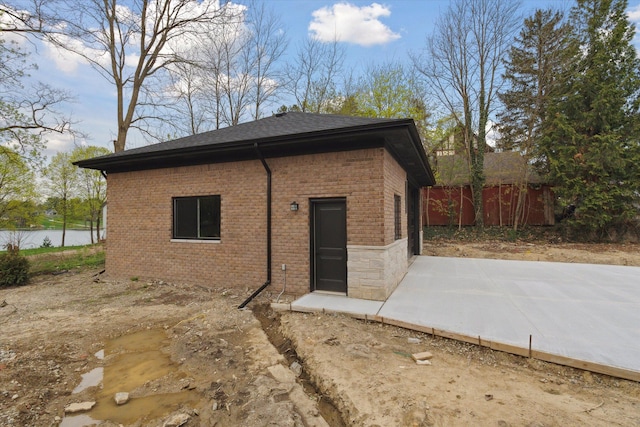 rear view of property featuring brick siding, fence, and a patio area