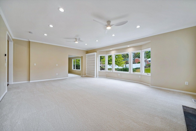 carpeted spare room with ceiling fan and ornamental molding