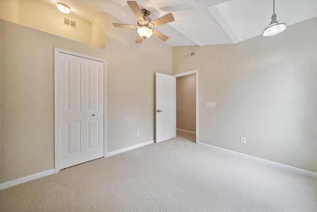 unfurnished bedroom featuring ceiling fan, a closet, and light colored carpet