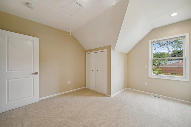 additional living space featuring lofted ceiling and light carpet