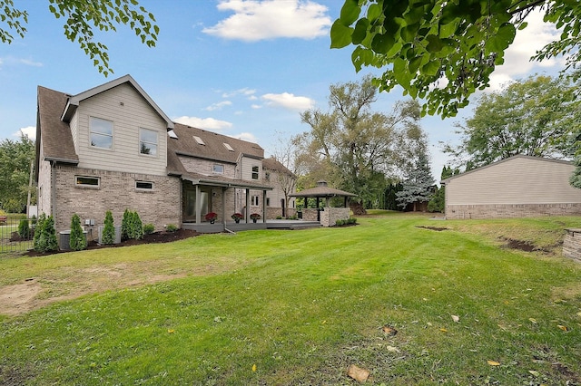 rear view of property with a gazebo, cooling unit, and a yard