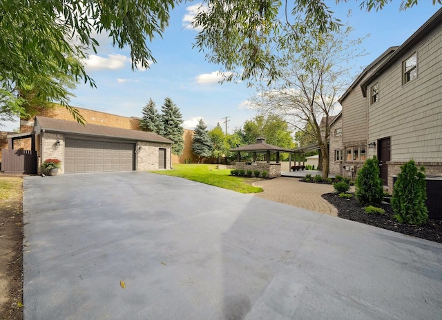 view of front of property featuring a gazebo, a garage, and a front yard