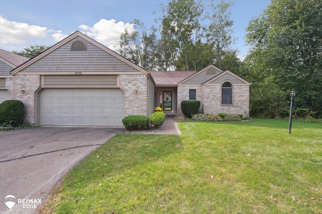 view of front of property featuring a garage and a front lawn