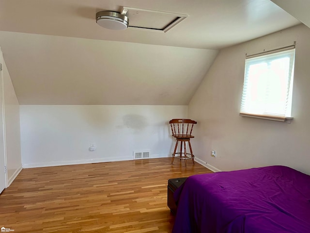 bedroom with hardwood / wood-style flooring and lofted ceiling