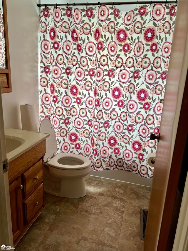 bathroom with curtained shower, vanity, and toilet