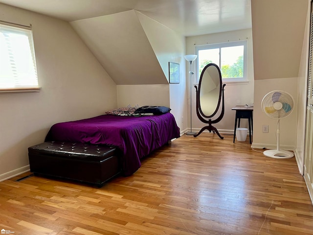 bedroom with light hardwood / wood-style floors and lofted ceiling