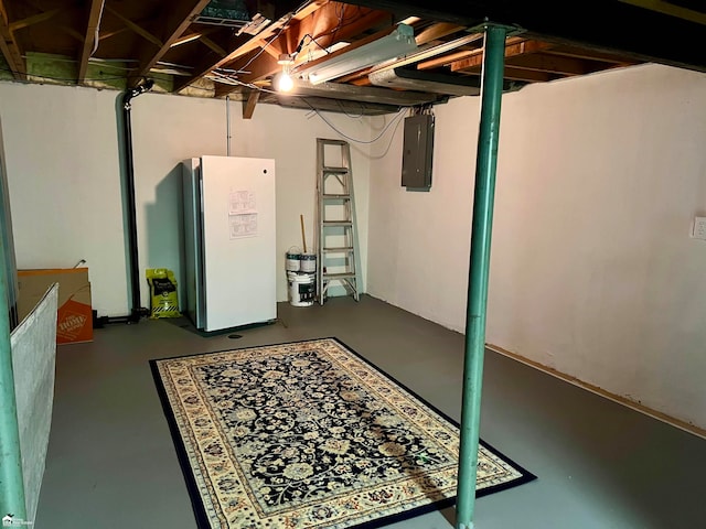 basement featuring electric panel and white fridge