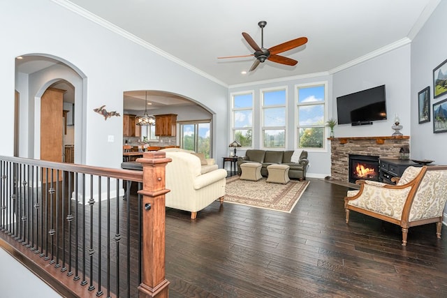 living room featuring crown molding, hardwood / wood-style flooring, a stone fireplace, and ceiling fan