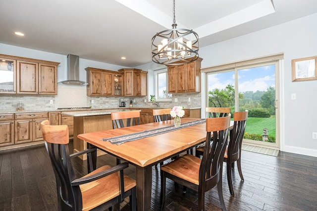 dining space with sink, an inviting chandelier, and dark hardwood / wood-style flooring