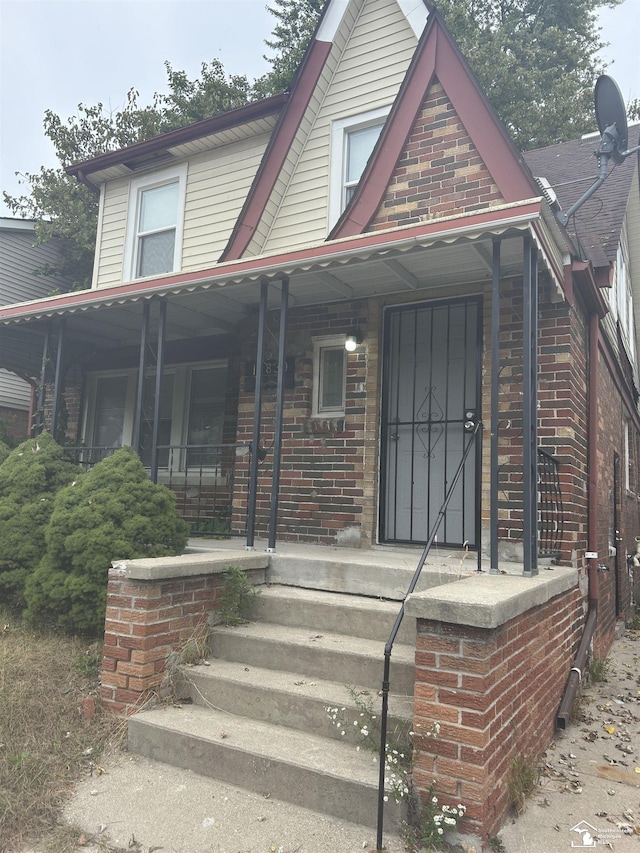 view of front facade featuring covered porch and brick siding