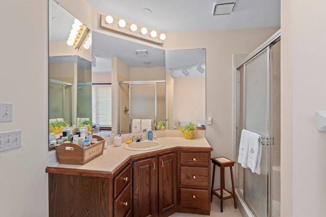 bathroom featuring vanity, a textured ceiling, and walk in shower