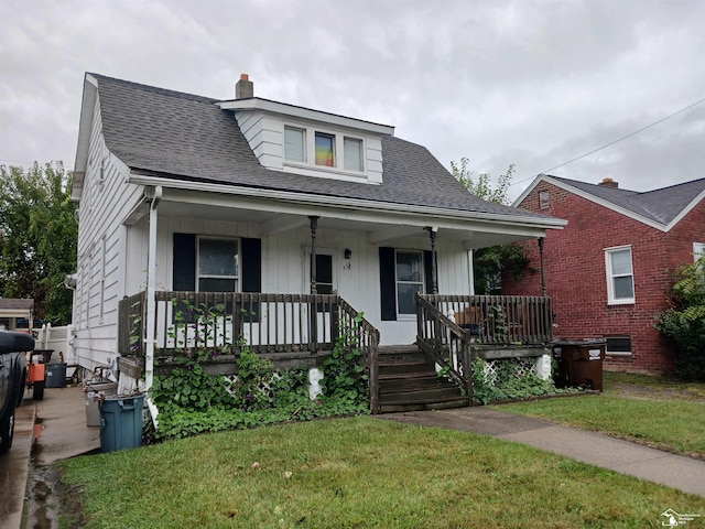 bungalow-style home with covered porch and a front yard