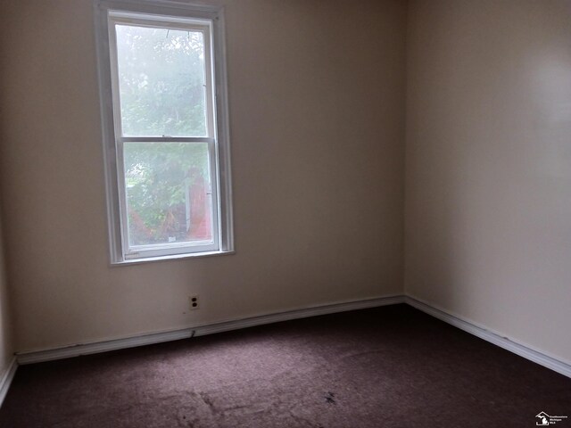639 Michigan Ave, Monroe, MI 48162 - unfurnished room featuring a healthy amount of sunlight, baseboards, and dark carpet