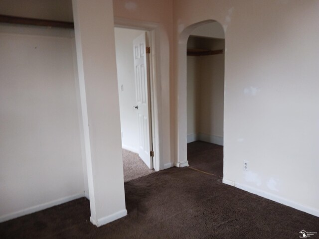 unfurnished room featuring dark colored carpet