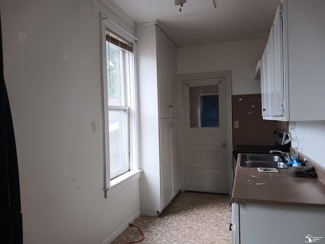 639 Michigan Ave, Monroe, MI 48162 - kitchen with a sink, dark countertops, white cabinetry, baseboards, and light floors