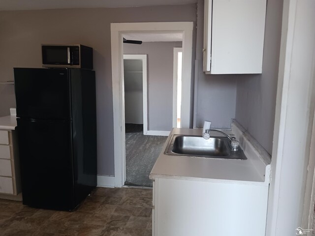639 Michigan Ave, Monroe, MI 48162 - kitchen with a sink, stainless steel microwave, white cabinetry, freestanding refrigerator, and light countertops