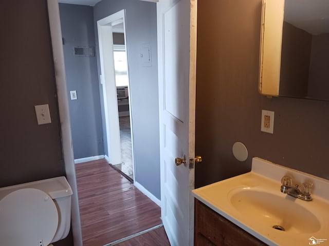 639 Michigan Ave, Monroe, MI 48162 - half bath with baseboards, toilet, wood finished floors, and vanity