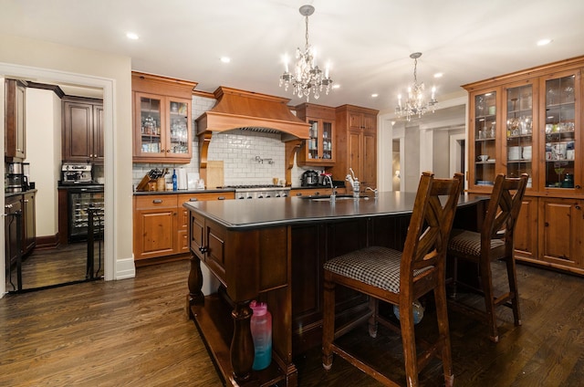 kitchen with decorative backsplash, dark hardwood / wood-style flooring, premium range hood, and a chandelier