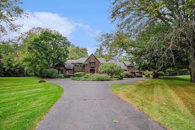 tudor-style house featuring a front yard