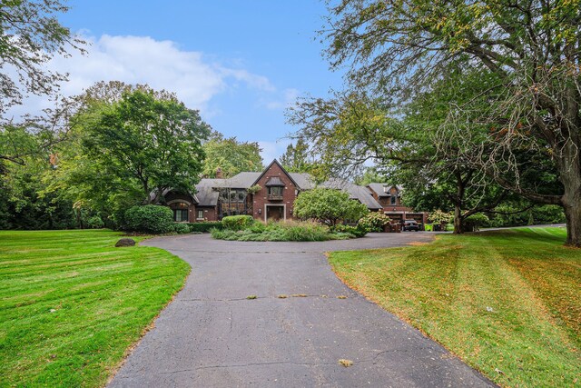 26061 Hawthorne Dr, Franklin, MI 48025 - tudor home with a front yard, asphalt driveway, and a chimney