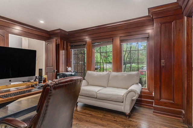 living room with wood walls, dark hardwood / wood-style flooring, and ornamental molding