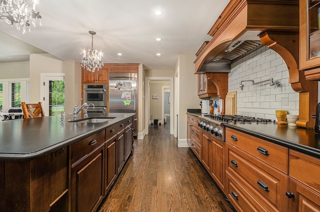 kitchen featuring dark wood-type flooring, hanging light fixtures, decorative backsplash, appliances with stainless steel finishes, and a notable chandelier