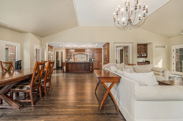 living room with an inviting chandelier, dark hardwood / wood-style floors, and vaulted ceiling