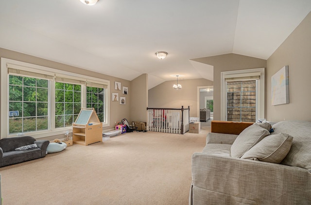 living room with carpet flooring, a chandelier, and vaulted ceiling